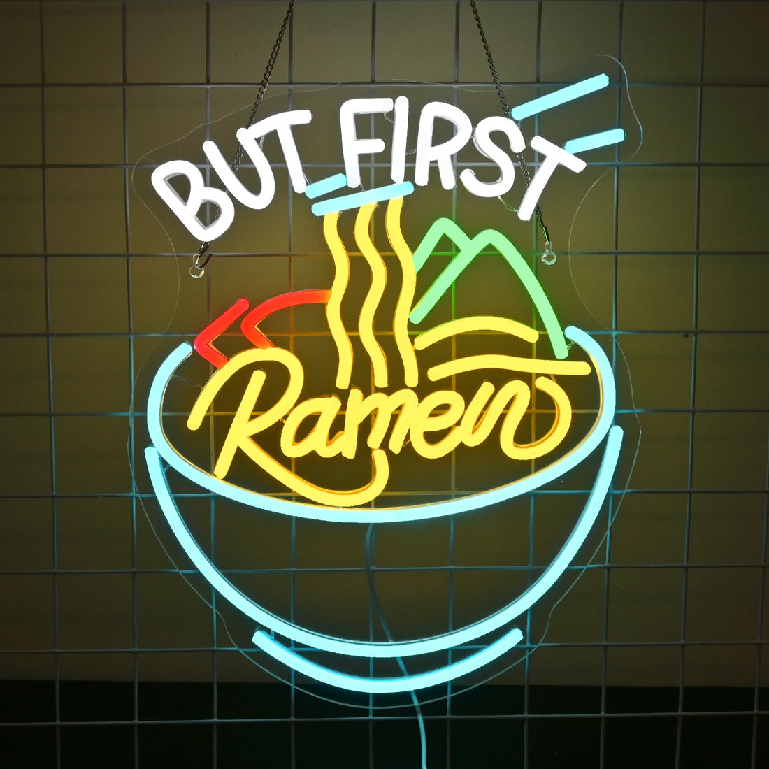 Neon sign with 'But First, Ramen' text on a brick wall background