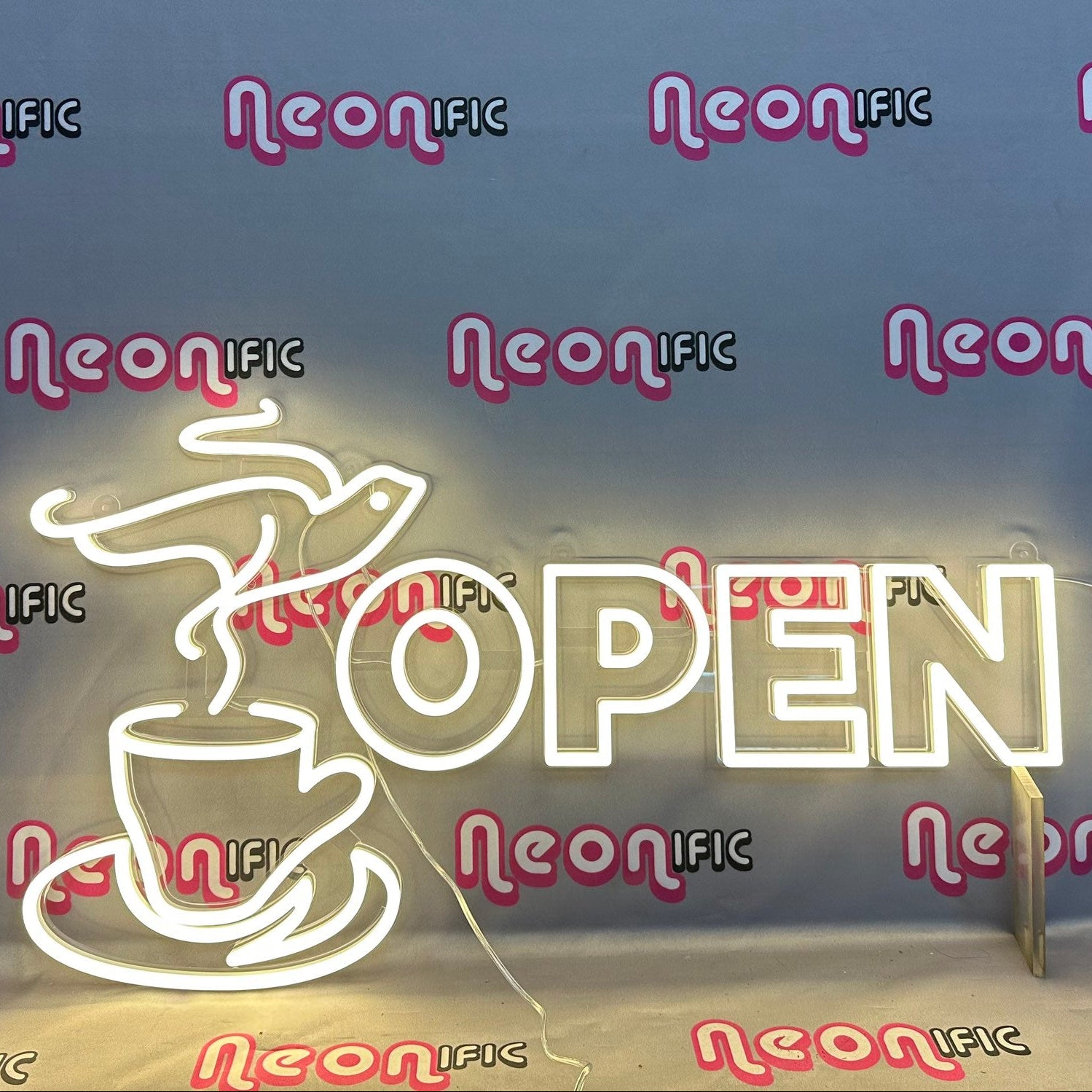 Neon 'OPEN' sign with coffee cup design on a dark background with 'Neon IFC' branding.