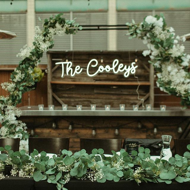 white neon sign in wedding that says &quot;The cooleys&quot;